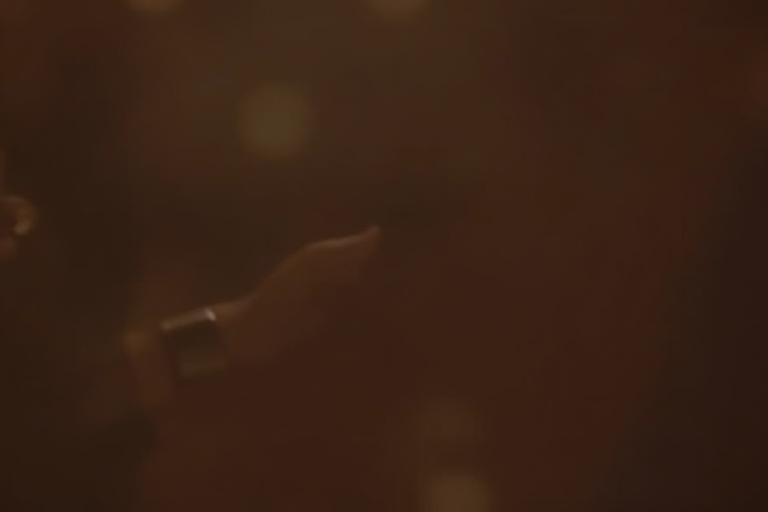 A person discretely checking a continuous glucose monitor (CGM) at a social event.